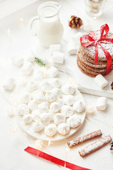 Fototapeta na wymiar Christmas cookies and marshmallows on a white background by the window