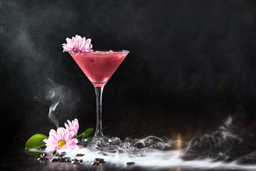 Pink cocktail on a black background in a high glass. Copy of space.