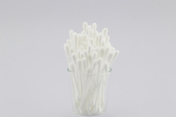 Many cotton swabs in the glass on white background