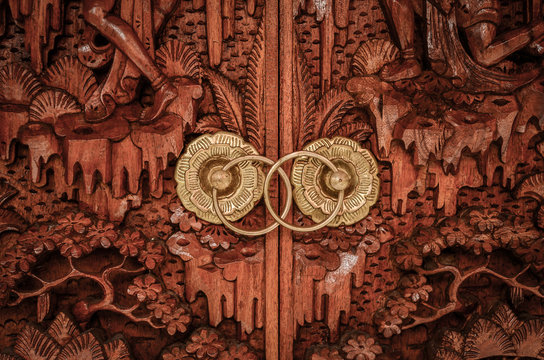Balinese traditional door handle made with golden metal and wood.