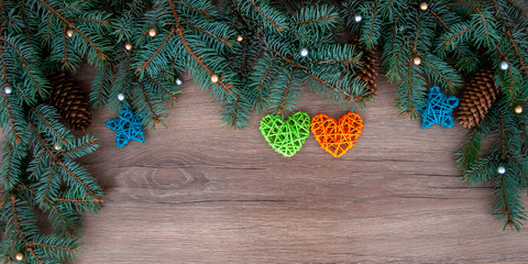 Christmas branches, cones, decorations on a wooden texture. Holiday Christmas background
