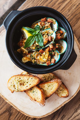 Top view of Steamed New Zealand Mussel with chorizo sausage, lemon  and white wine sauce. Served with garlic bread.