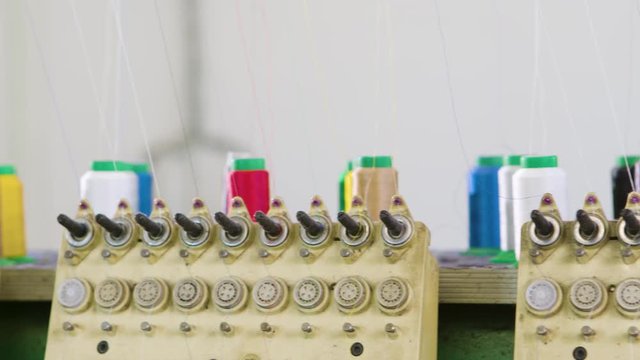 Dolly shot of sweing machine in a clothing factory