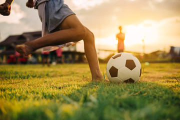 Silhouette action sport outdoors of a group of kids having fun playing soccer football for exercise...