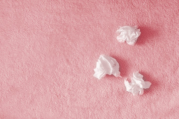 Crumpled handkerchiefs, paper napkins on a pink background with a fluffy carpet. The concept of illness, snot, insomnia and tears. Place for text, copy space