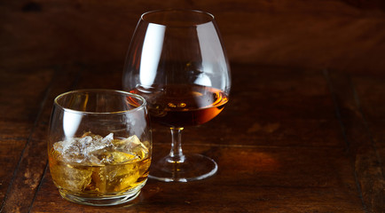 Whisky on the rocks and cognac in a snifter