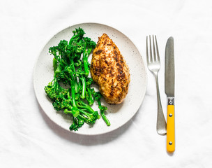 Healthy diet lunch - baked chicken breast and boiled broccoli cabbage on a light background, top view