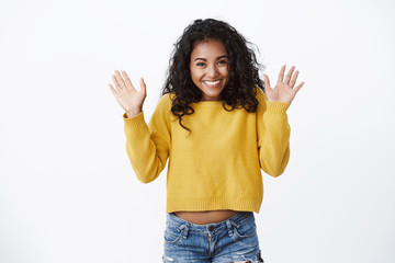 Happy pretty african american girl with curly hair showing excitement and happiness, greeting...