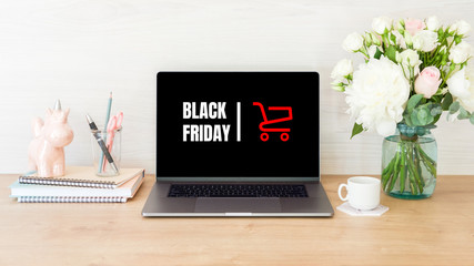 Black friday concept. Laptop screen with shopping card and sign 