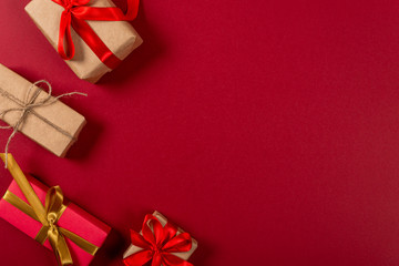 Gifts with wrapping ribbon. Creative christmas concept. Red background.