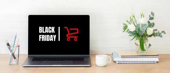 Black friday concept. Laptop computer screen with shopping card and sign 