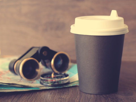 Black disposable coffee Cup and binoculars, travel