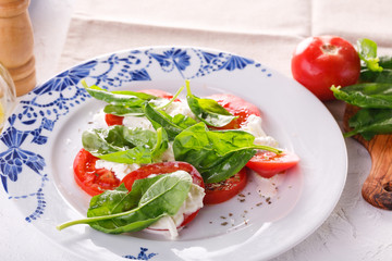salad of fresh tomatoes, young cheese and fresh spinach.