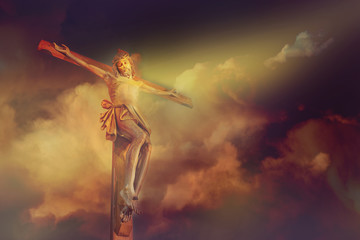 Jesus Christ crucifixion on cross with dramatic cloud over calvary sunset background