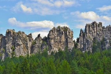 Fototapeta na wymiar Beautiful sandstone rocks set in forest. Mala Skala, Bohemian Paradise, Czech Republic. Blue sky, white clouds.