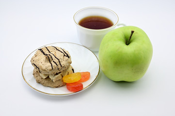 Photo on a white background apple, cake, cup with tea on a saucer. The concept of a delicious breakfast, lunch, healthy food.