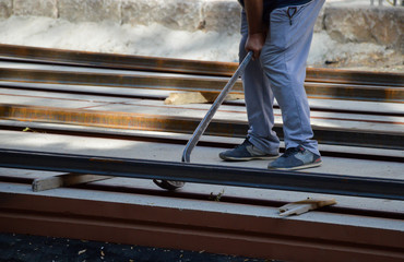 Worker raises a tram rail with a crowbar when laying