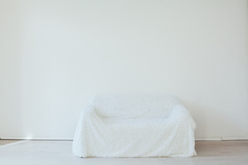 white sofa in the interior of an empty white room
