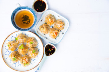 Cantonese Dimsum food cuisine . Fresh  prawn wrapped in yellow dumplings, Steamed Chinese wrapped in yellow Dumplings.White wood flooring  background, space.Chinese popular dim sum food.