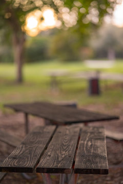 Wood picnic tables in the park blurry background