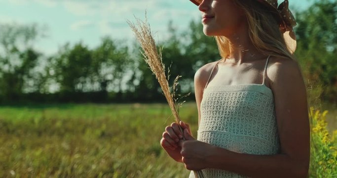 Portrait smiling preteen girl in straw hat is in the field at Sunny Day. Child looking at camera. Slow motion. Gimbal short