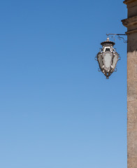 Details of the ornate wall lamp against clear blue sky with copy space
