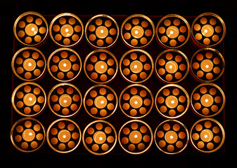 view from above of heap of lit cemetery grave candles in the dark