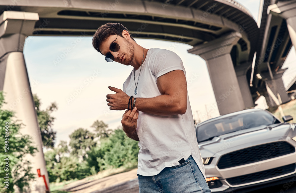 Wall mural Handsome man near car