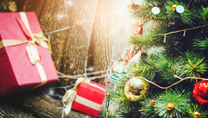 Fototapeta na wymiar Christmas tree with red gift box and firewood background