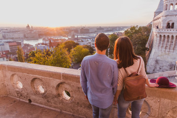 Young couple enjoy the view from the point from Fisherman Bastion in Budapest during sunrise.