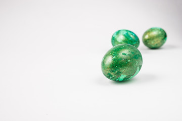 three green easter eggs on  white table