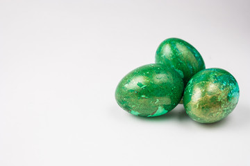 three green easter eggs on  white table