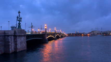 Fototapeta na wymiar Saint-Petersburg. Russia. Petersburg evening. Trinity Bridge with evening lights is reflected in the Neva River.
