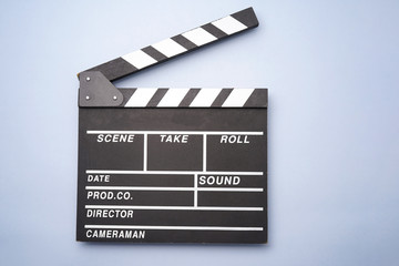 Fototapeta na wymiar Filmmaker profession. Clapperboard on blue background top view copyspace