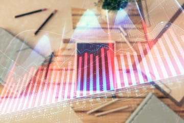 Double exposure of forex graph on digital tablet laying on table background. Concept of market analysis