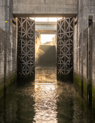Obraz premium Solid wooden lock gates opening to show the mist from sunrise at the Crestuma Lever dam on River Douro in Portugal