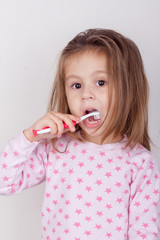 Cute little girl brushing her teeth