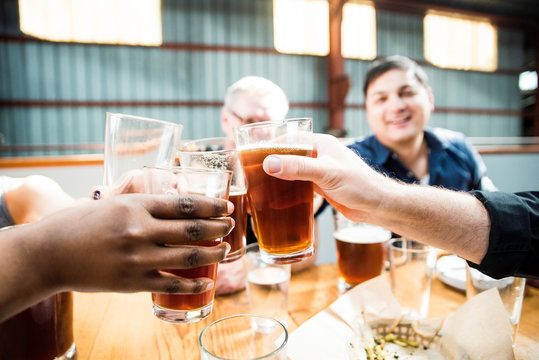 Diverse Group Of Friends Cheering For Beer