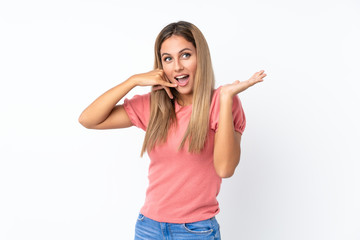 Young blonde woman over isolated white background making phone gesture and doubting