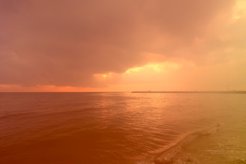 Obraz premium sunrise through the cloud over the sea and fantastic color of light