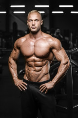 Fototapeta na wymiar Handsome strong athletic men pumping up muscles workout fitness and bodybuilding concept background - muscular bodybuilder fitness man doing abs exercises in gym naked torso.