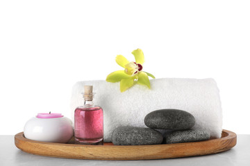 Obraz na płótnie Canvas Tray with towel and spa supplies on grey table against white background