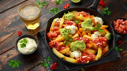 Loaded potato nachos with melted cheddar cheese, sour cream, tomato salsa, chilli, guacamole and beer