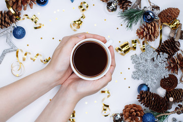 Woman hands with cup of coffee on Christmas and New Year background.