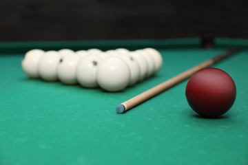 Billiard balls and cue on table indoors