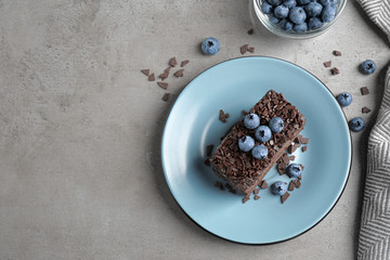 Fototapeta na wymiar Delicious fresh chocolate cake served with blueberries on grey table, flat lay. Space for text