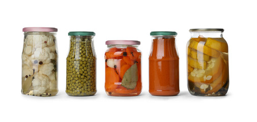 Different jars with pickled vegetables on white background