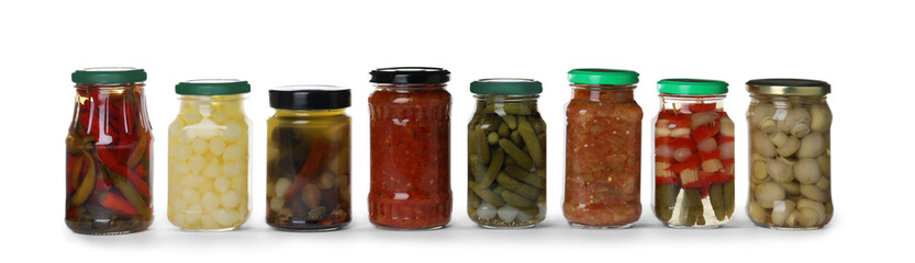 Different jars with pickled vegetables on white background