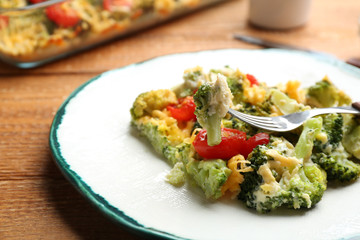 Tasty broccoli casserole served on wooden table, closeup