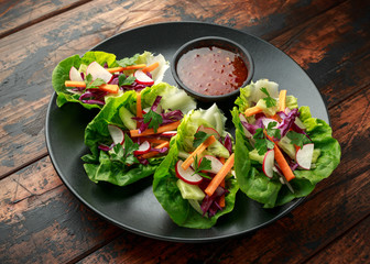 Vegetable lettuce wraps with carrot, onion, radish, red cabbage, cucumber and sweet chilli sauce